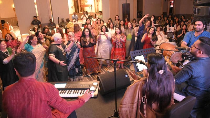 Young people dancing with raised hands at a bhajan clubbing event in Chennai, India
