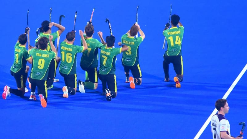 Hockey captain Tom Boon celebrating with teammates after scoring hat-trick goal