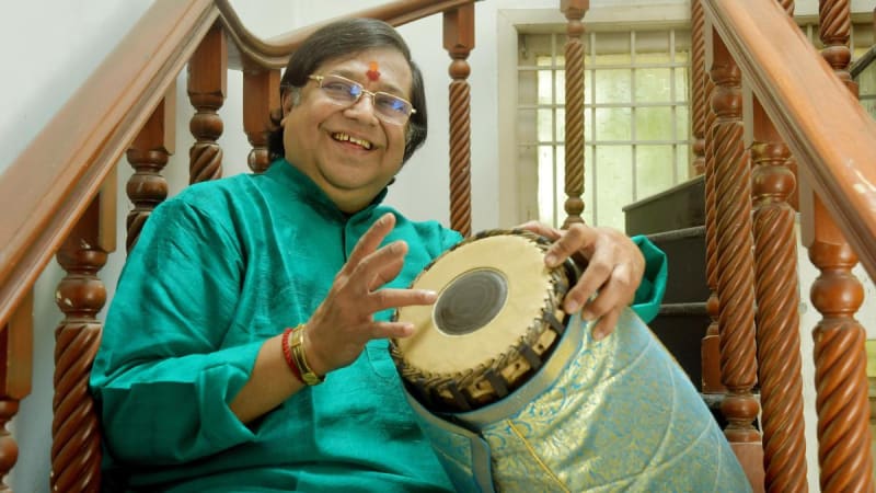 Elderly Indian musician Thiruvaarur Bakthavathsalam playing traditional mridangam drum instrument in Chennai