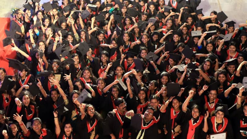 Happy college students in Kerala celebrating on campus with books and graduation caps