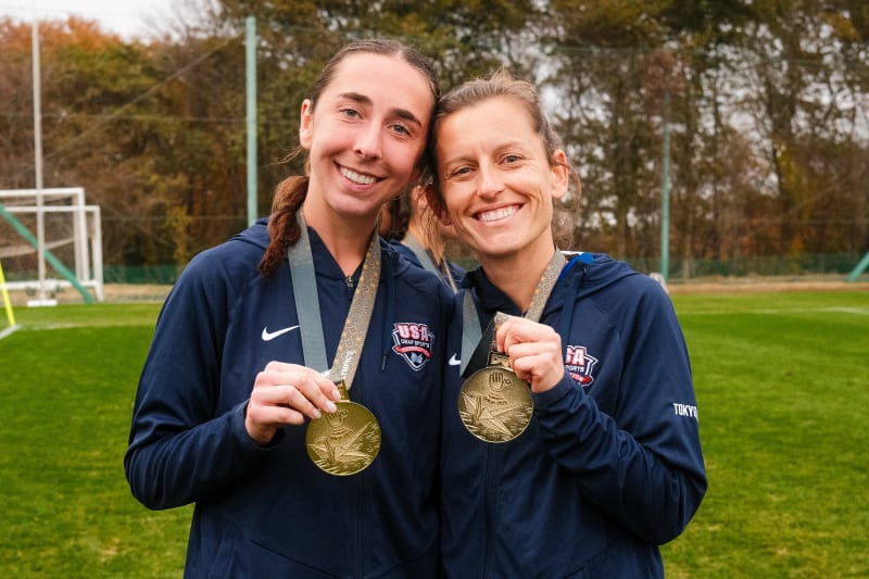 Pediatric nurse Paige Beaudry holding Olympic gold medal with U.S. Women's Deaf National Soccer Team