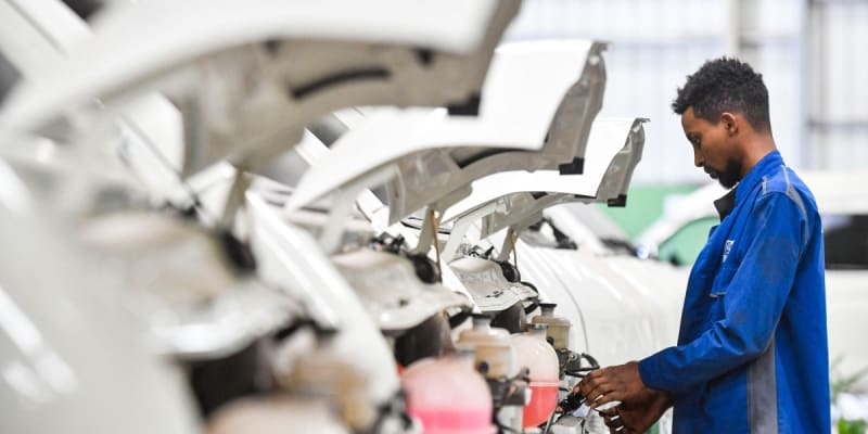 Electric motorbike charging at battery swap station in African city street