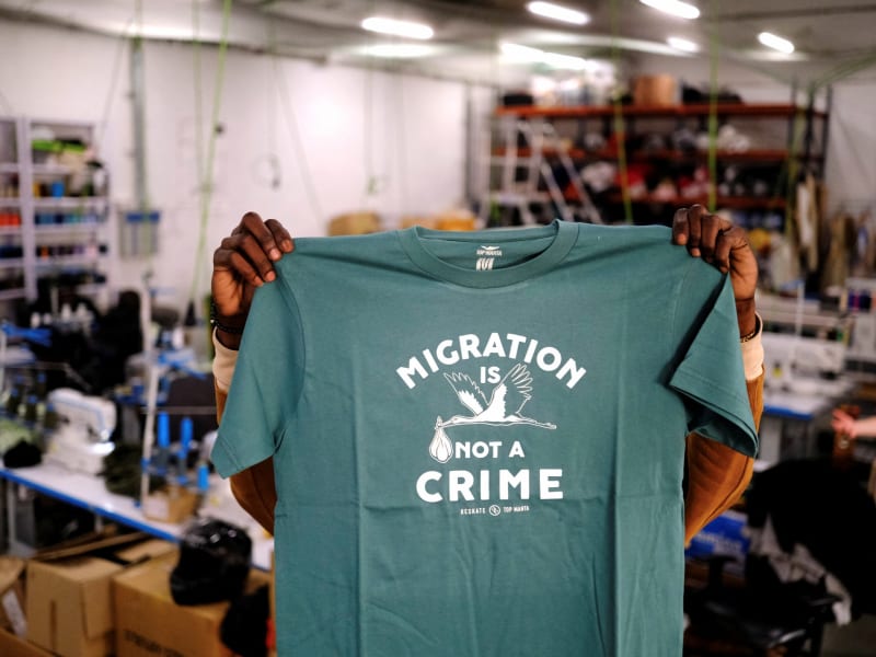 Migrant worker in Barcelona holding clothing, symbolizing path from informal to legal employment