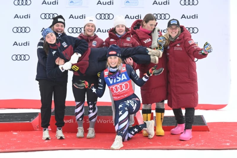 Mikaela Shiffrin celebrating on podium with trophy after historic ninth World Cup slalom title