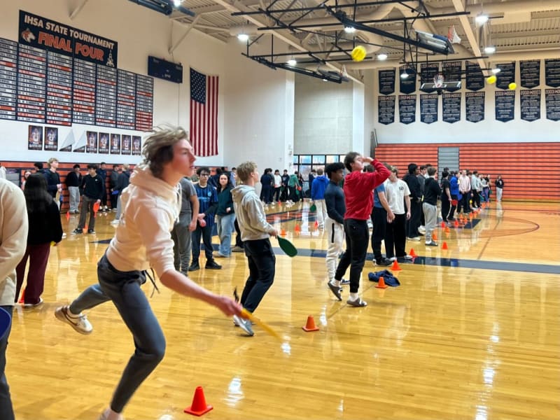 Teenage student lunges with pickleball paddle during world record attempt at Illinois high school