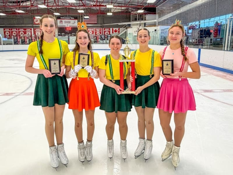 Five young female figure skaters in competition attire celebrating their Ohio state championship victory