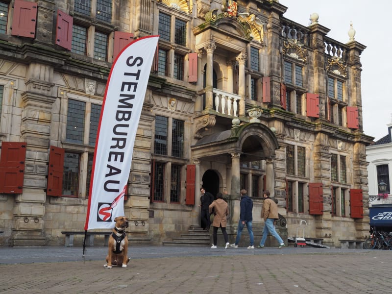 Dutch voting location exterior with people entering building for local council elections