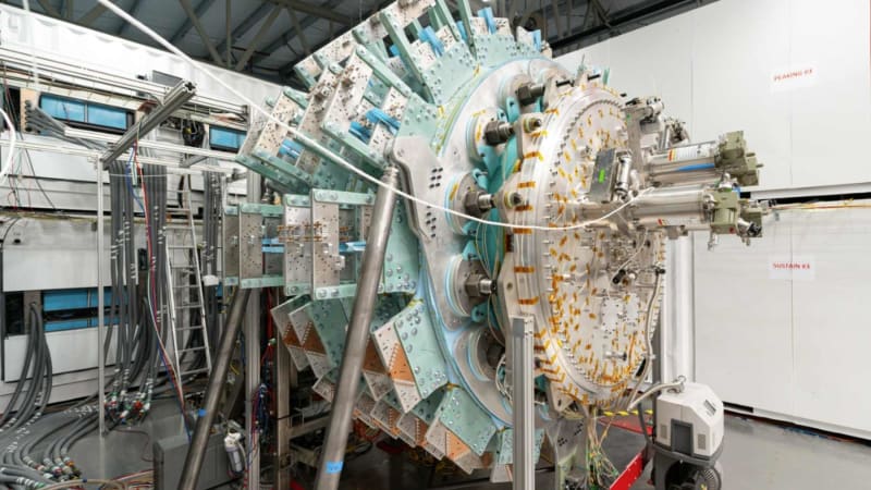 Glowing plasma contained within spherical fusion reactor chamber with liquid metal compression system visible around edges