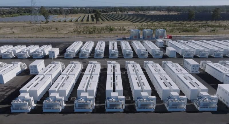 Modern utility-scale battery energy storage facility in Western Australia with solar panels under blue sky