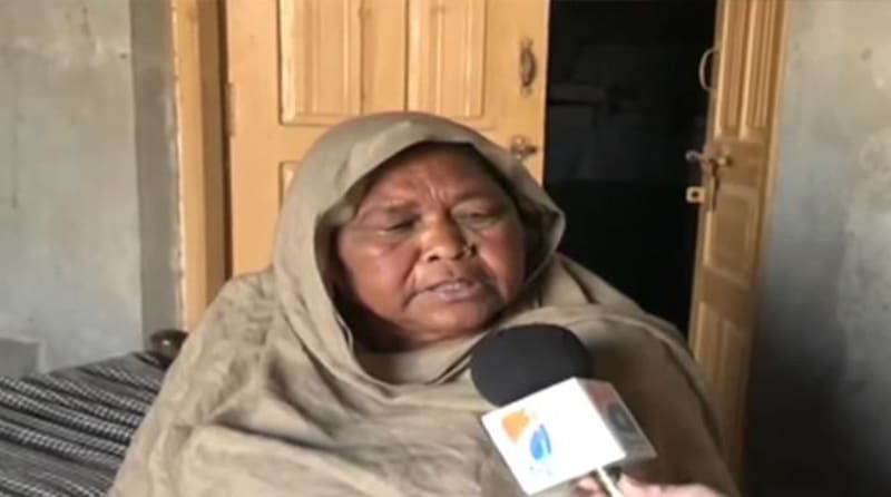 Elderly woman in traditional clothing speaking emotionally about family reunion after decades apart