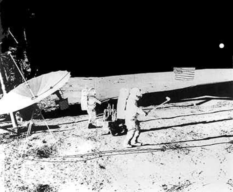 Black and white footage of astronaut Alan Shepard swinging golf club on lunar surface