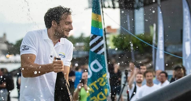 French sailor Charlie Dalin celebrating his record-breaking Vendée Globe victory with champagne on his boat