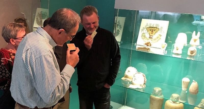 Museum visitor smelling scented card recreating ancient Egyptian mummification aromas at German museum