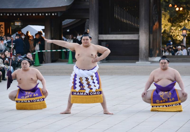 Sumo wrestlers performing ceremonial ring-entering ritual at Meiji Shrine with traditional attire and decorations