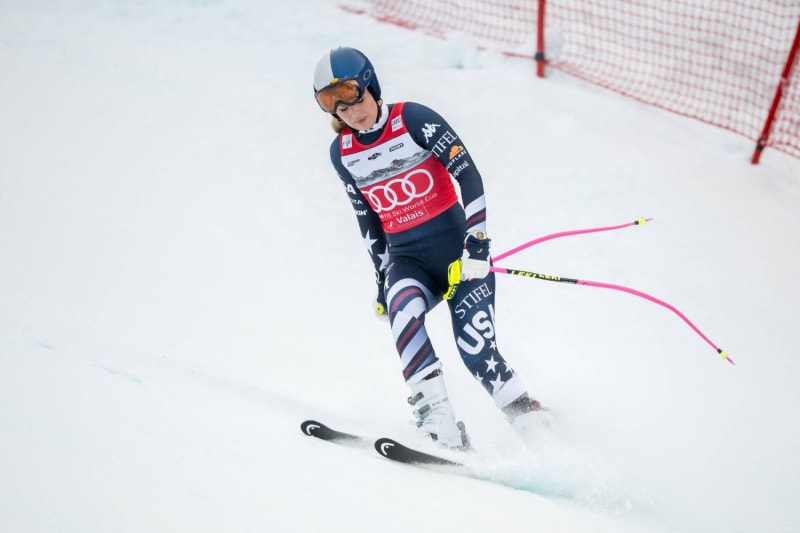 Olympic skier Lindsey Vonn racing downhill in competition gear on snow-covered mountain slope