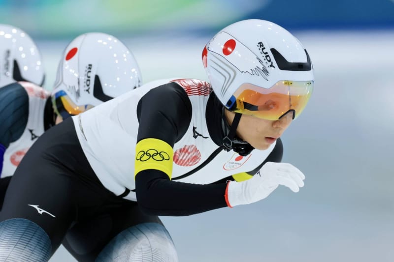 Miho Takagi and Japanese teammates celebrating bronze medal on Olympic podium in Milan