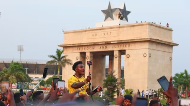 IShowSpeed holding Ghanaian passport, smiling at camera during citizenship ceremony in Ghana