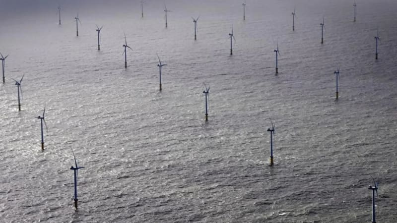 Offshore wind turbines standing in ocean waters with undersea cable infrastructure illustration
