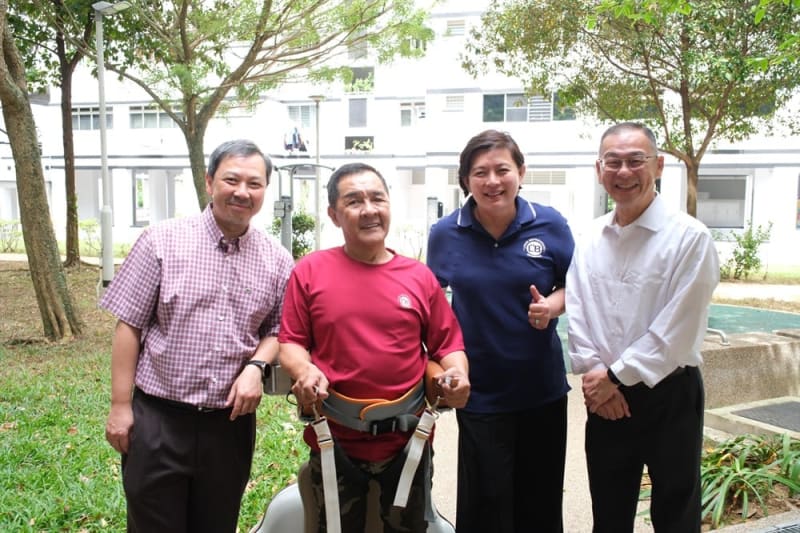Elderly person using robotic balance assistant device during exercise class at senior center