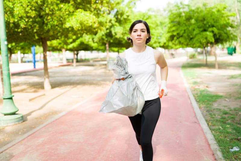 Group of runners in workout clothes volunteering together in urban rooftop garden