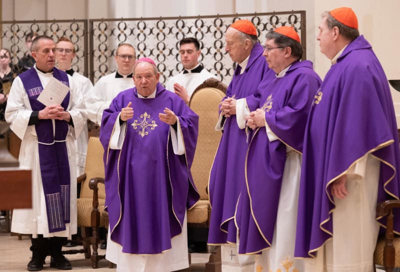 ** Catholic bishops and cardinals standing together at altar during solidarity Mass in Minnesota chapel