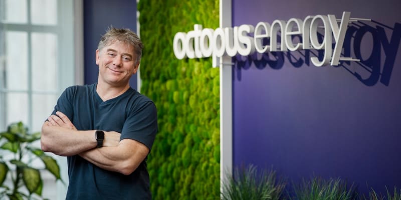 Wind turbines and solar panels generating renewable energy against blue sky symbolizing UK-China partnership
