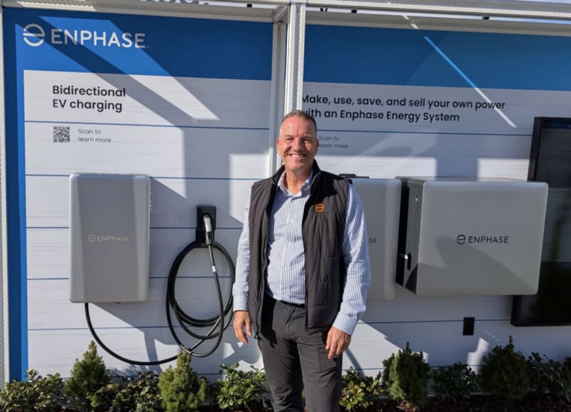 Bidirectional electric vehicle charger displayed at technology trade show connecting clean energy to computing