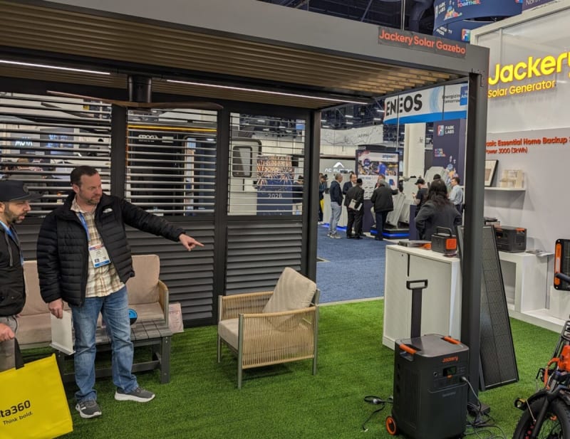 Modern aluminum gazebo with dark solar panels integrated into louvered roof in sunny backyard setting