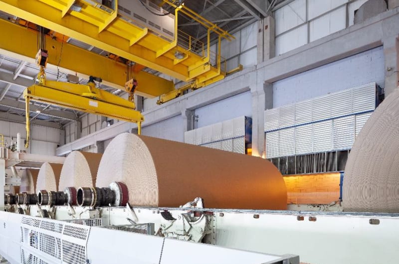 Large industrial heat pump machinery inside Finnish paper mill facility producing clean steam