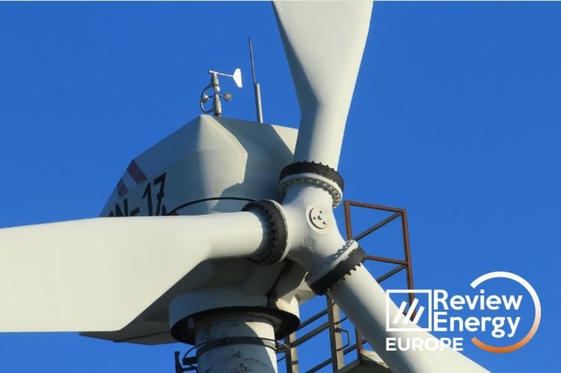 Modern wind turbines spinning against blue sky generating clean renewable energy in Europe
