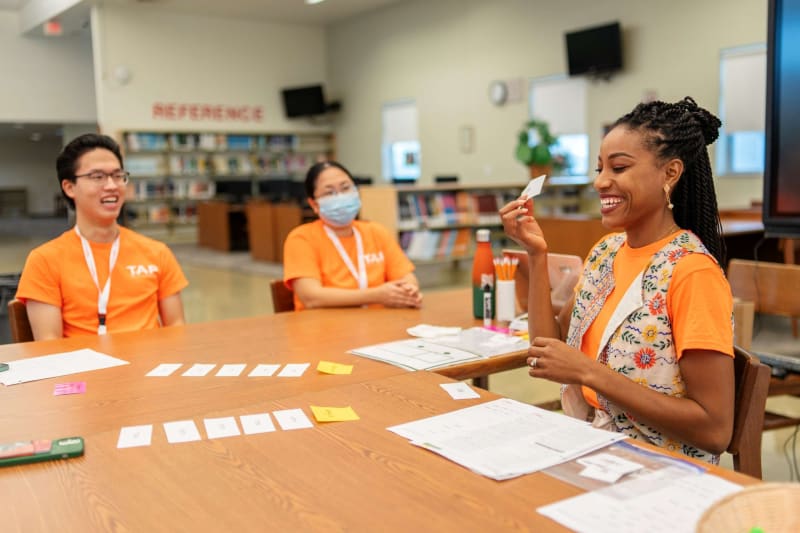 Diverse group of high school graduates in caps and gowns celebrating at Miami-Dade County graduation ceremony