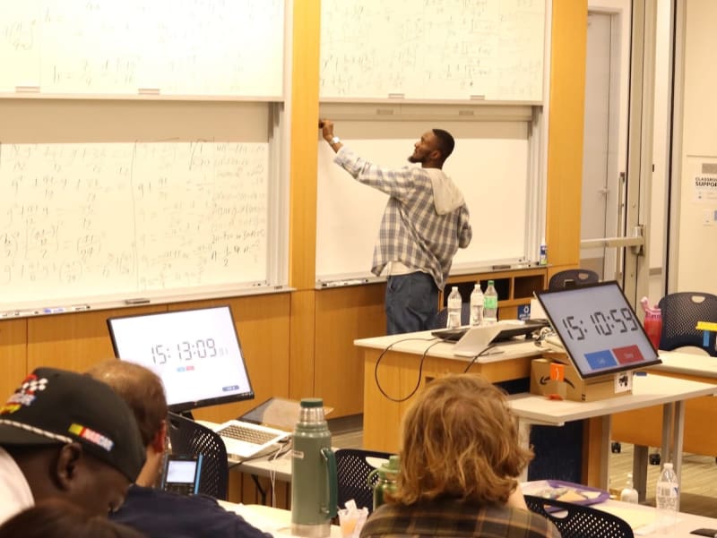 Emmanuel Onyegu teaching math on whiteboard during his 40-hour world record attempt