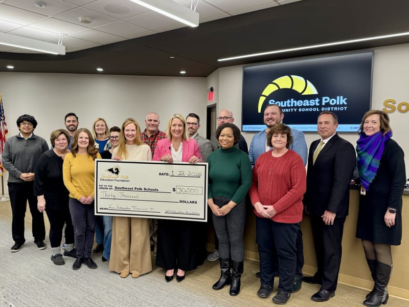 Large ceremonial check for thirty thousand dollars presented to school board members