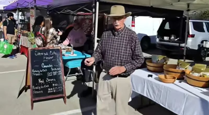 David Dominguez filming a video at a farmers market booth with a small business vendor