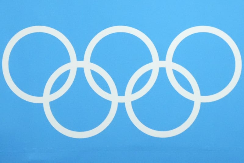 ** Olympic rings displayed at Winter Games venue with snow-covered mountains in background