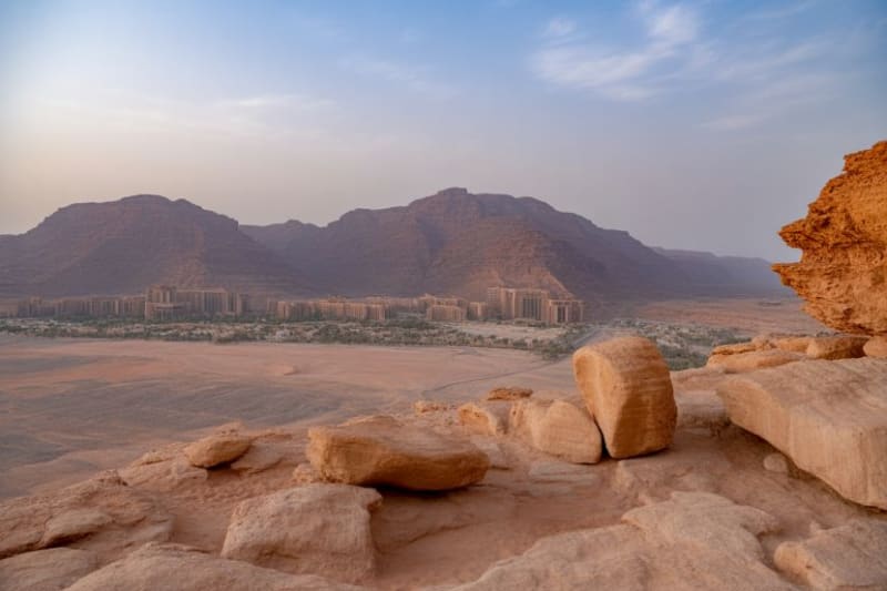 Tourists exploring ancient heritage sites in AlUla Saudi Arabia under clear blue skies