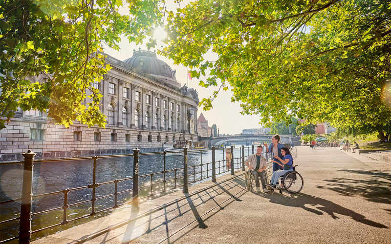 Diverse group of travelers including wheelchair users at modern accessible airport terminal with clear signage