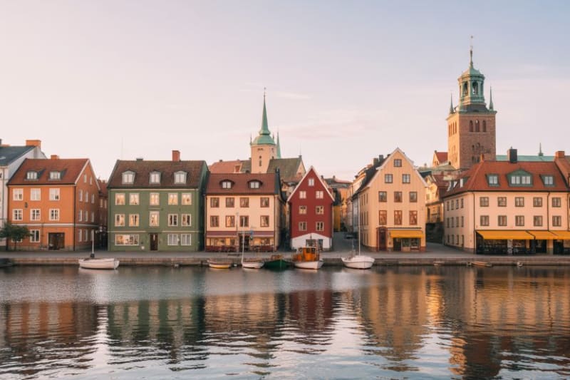 Electric bus traveling through historic Stockholm street with cyclists and pedestrians nearby