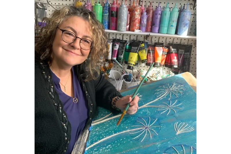 Dawn Michaelis working on three-dimensional mixed media artwork in her home studio