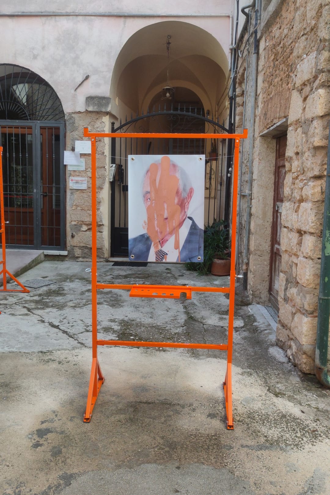 A frame holding the portrait of a man, in front of the arcade