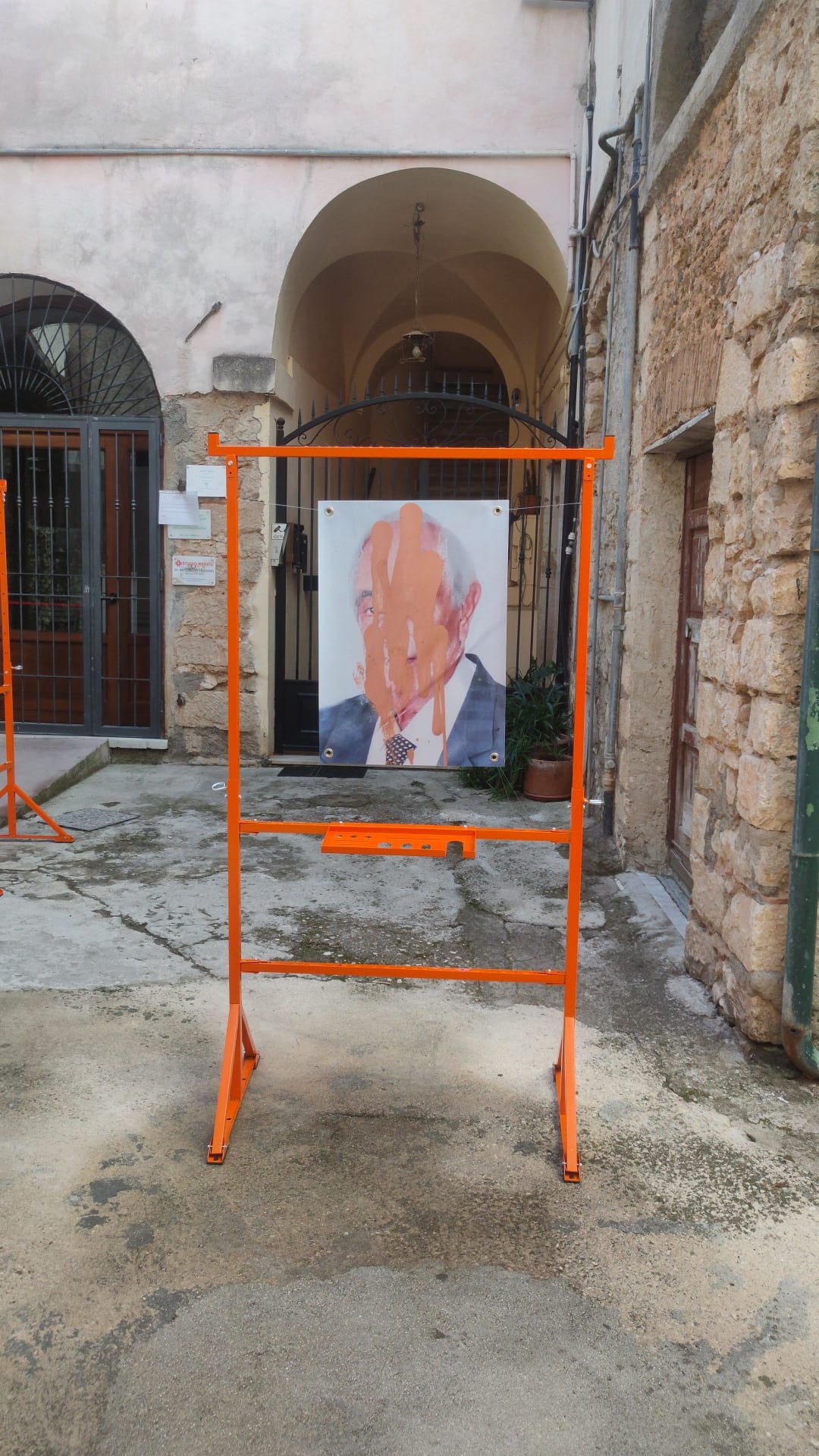 A frame holding the portrait of a man, in front of the arcade