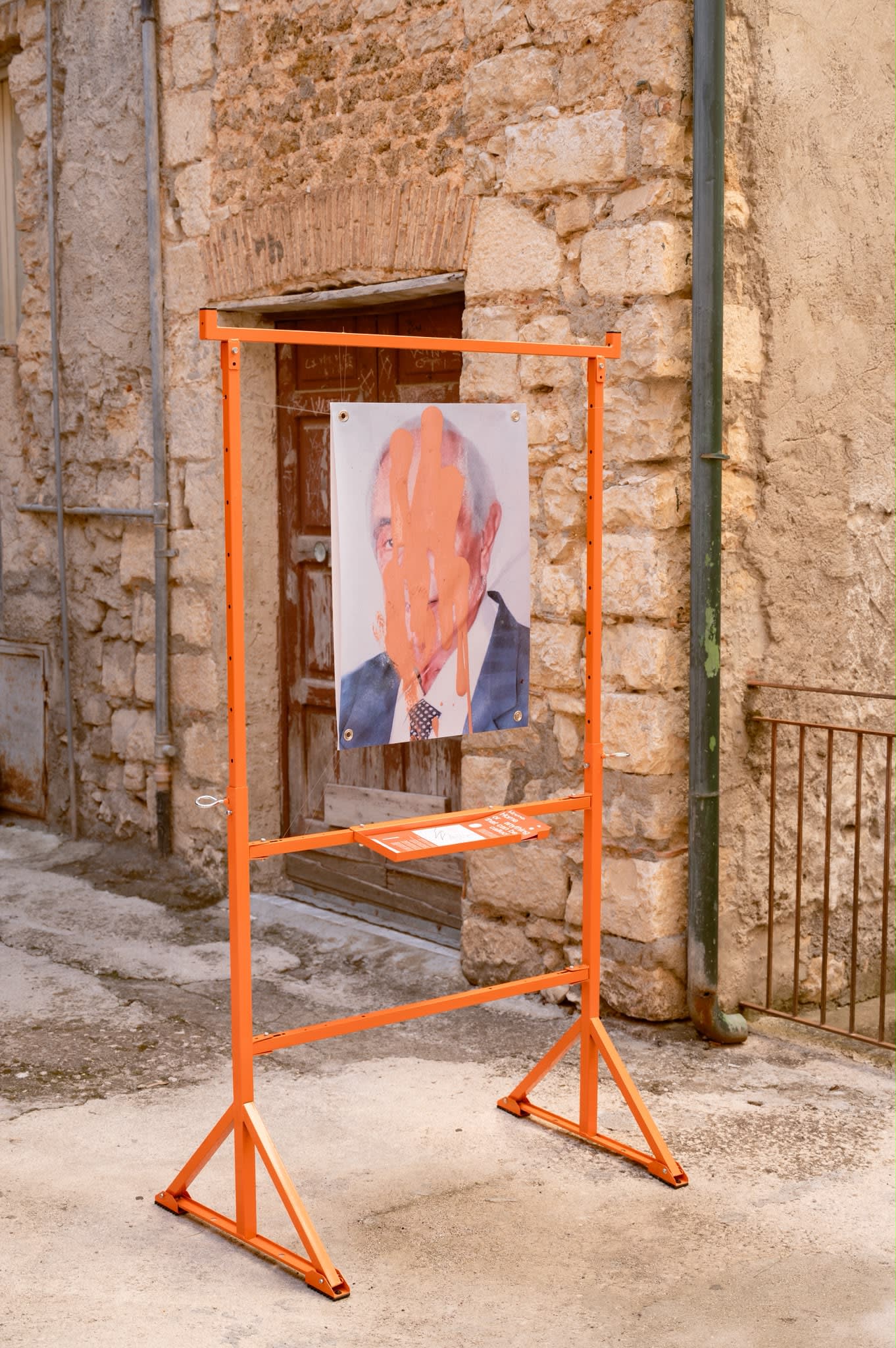 A frame holding the portrait in front of a wooden door