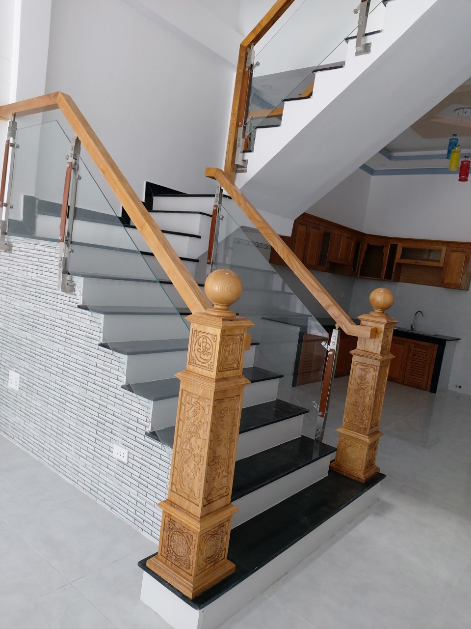 Cầu thang kính cường lực trụ cao ốp bên hông