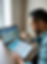 A person holding a credit report, looking stressed, with a laptop open showing a website about debt collection