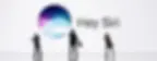 Silhouetted figures walk in front of a white backdrop featuring the Siri logo and text "Hey Siri". The mood is modern and tech-focused.