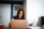 Female on laptop on dinning room table going over her finances