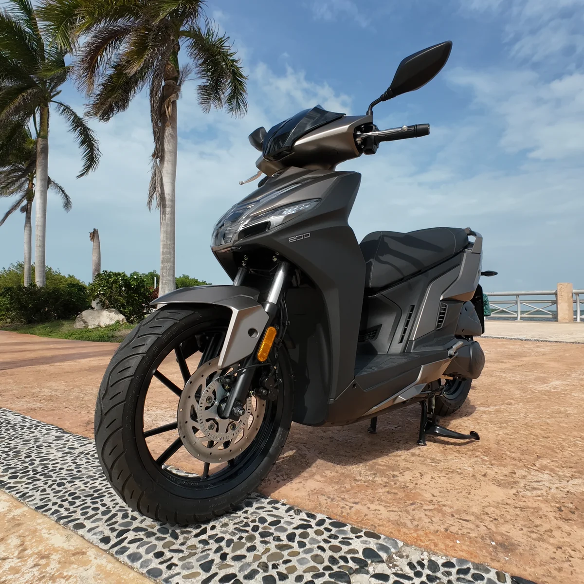 VibeScoot scooter parked on scenic beach road in Cancun