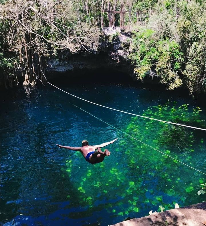 Traveler jumping from platform into Cenote Verde Lucero