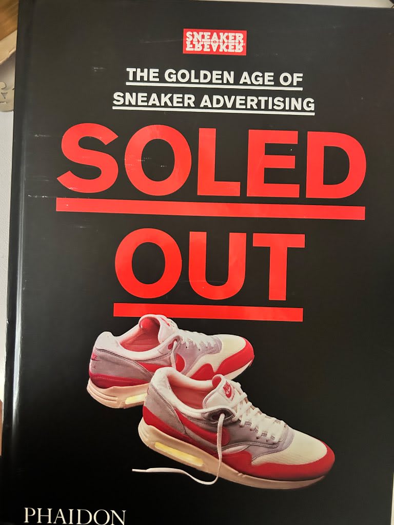 Large format hardback book Soled Out showing vintage sneaker advertising campaigns from Nike Adidas Converse and Reebok on wh