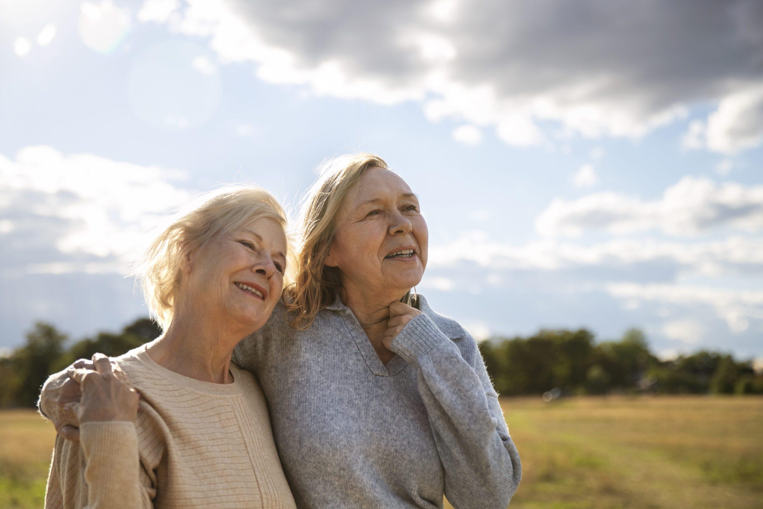 Dos mujeres mayores sonriendo en la naturaleza